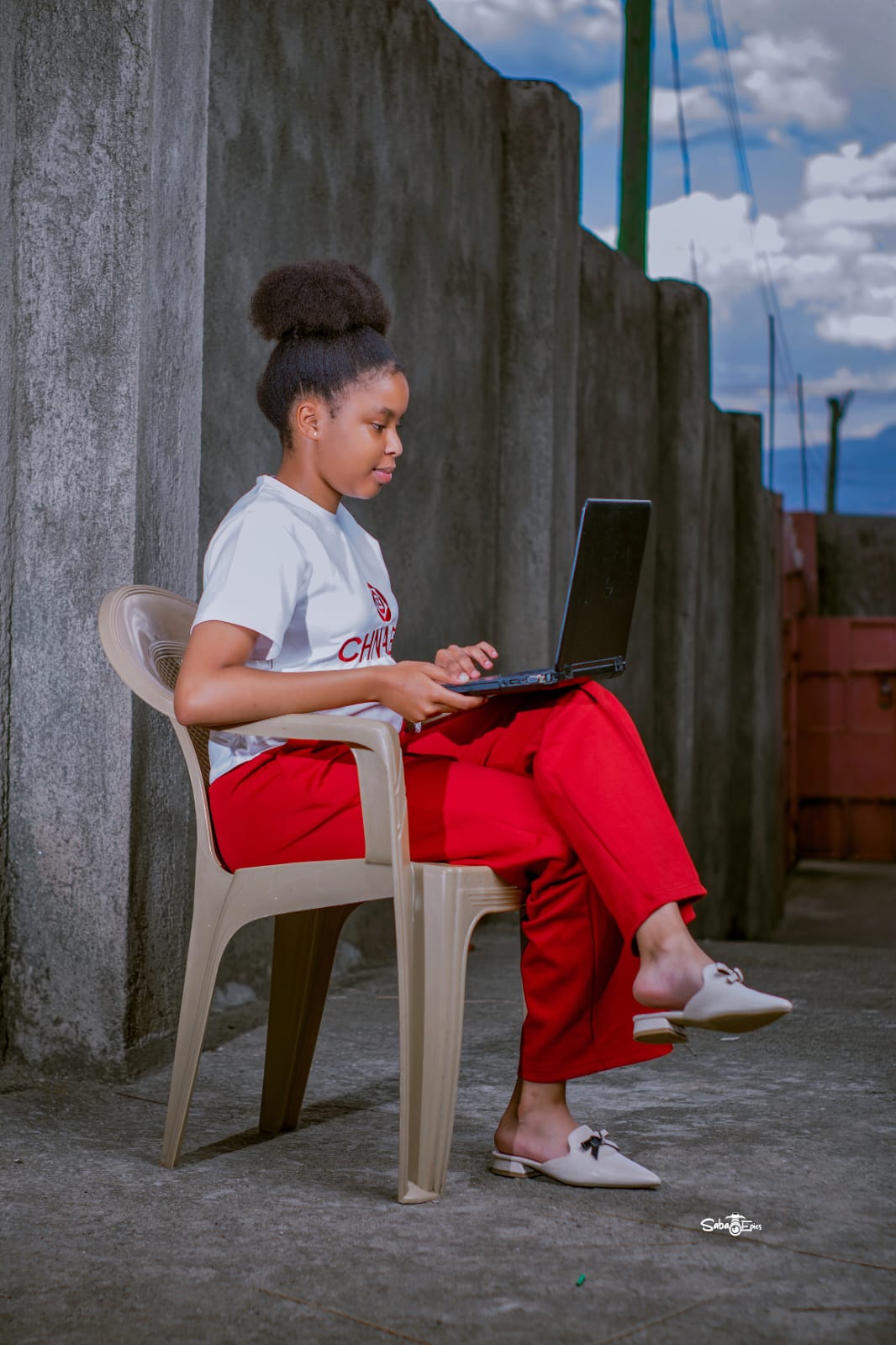 A learner using a laptop outdoors